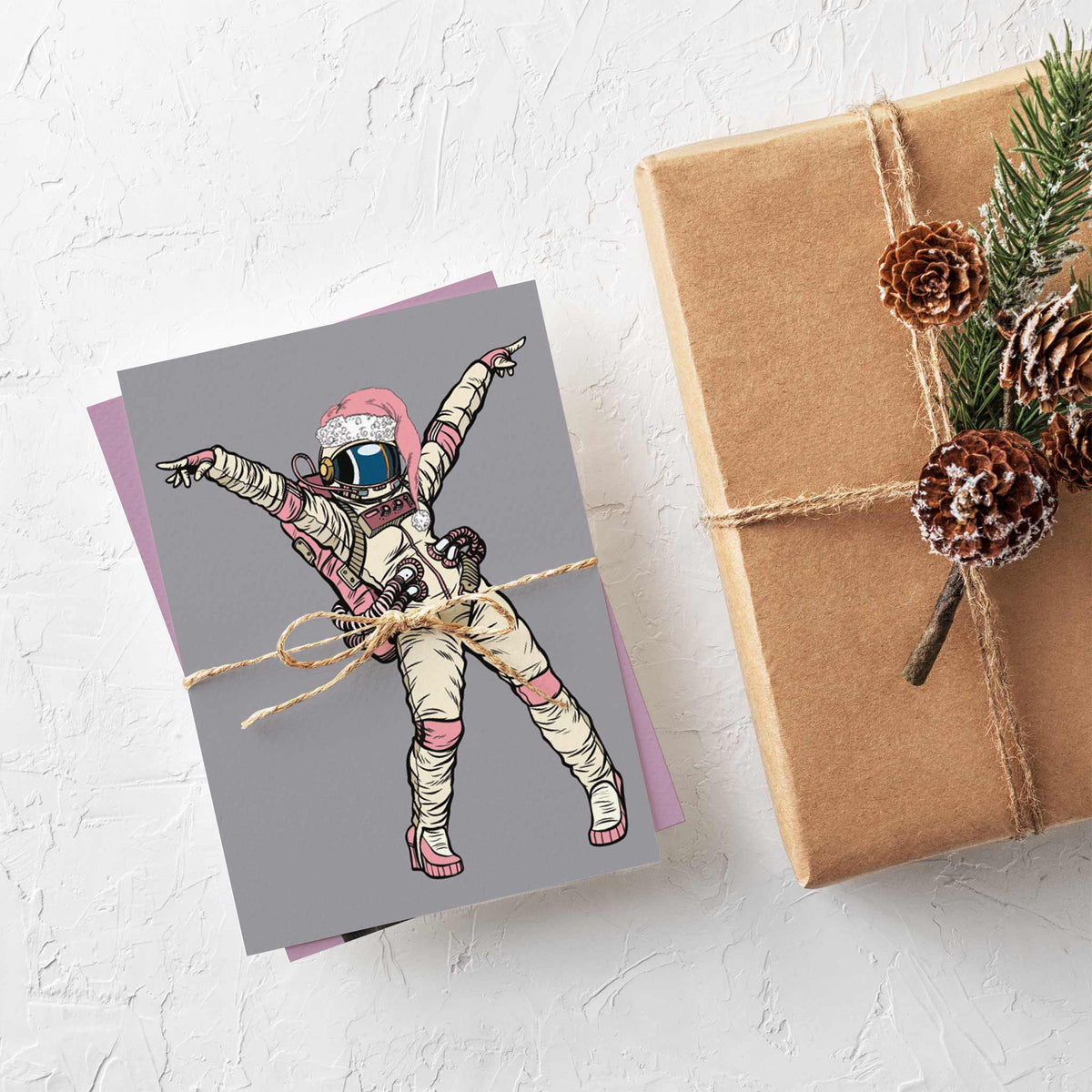 Christmas cards featuring purple and green crosshatched T. rexes in sunglasses and Santa hats wrapped in multicolor string li