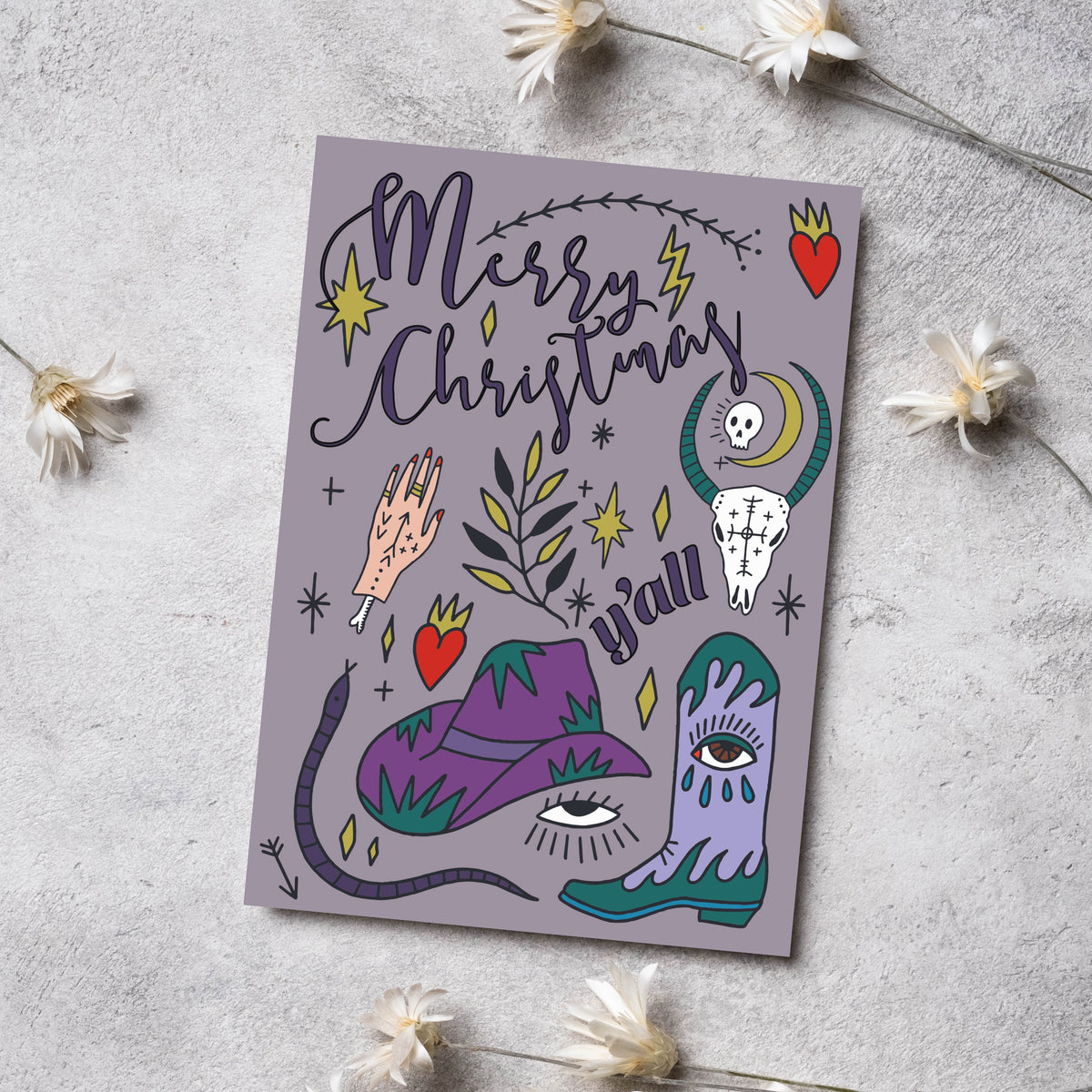 Holiday card set of 24 with Western and folk art illustration elements, dark outlines, green snake, and gold accent shapes.