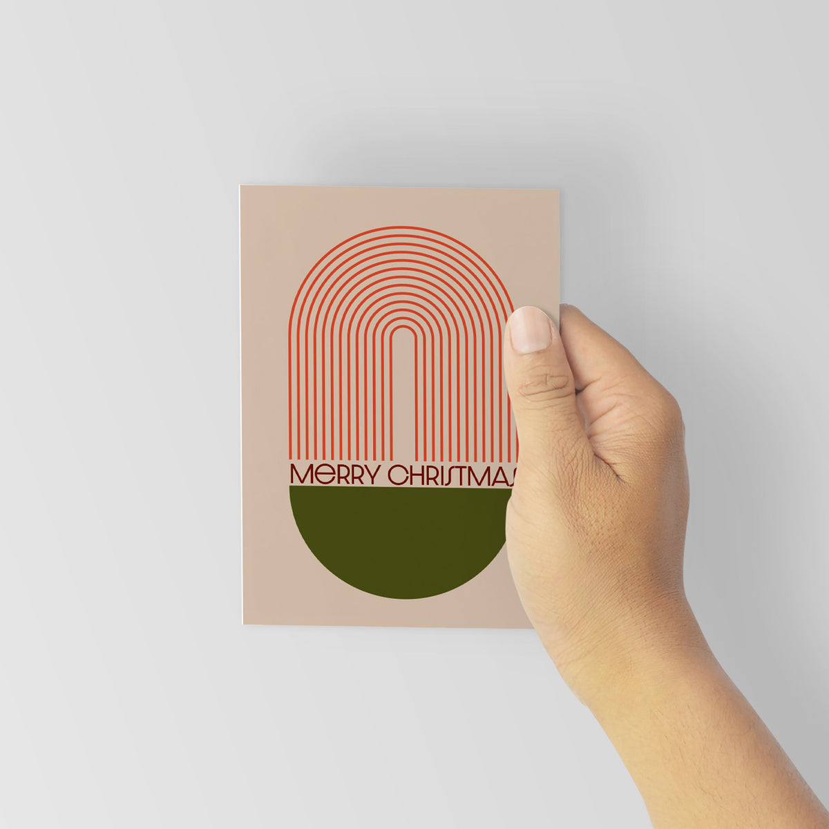 Holiday cards with knocked-out typography on maroon and olive half-circle bowls, set against lilac, tan, and mauve background