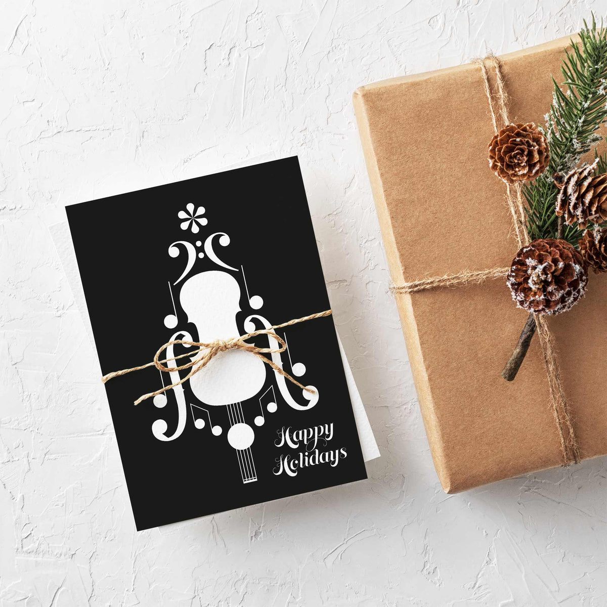 Black and white music holiday cards with a notation-built string instrument and "Happy Holidays" set in two-line script.