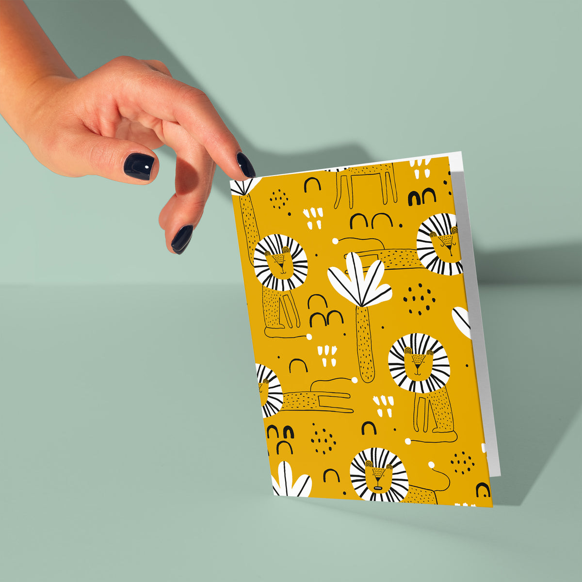 Boxed greeting card set with a repeating illustrated lion pattern in mustard yellow, black, and white, no text.