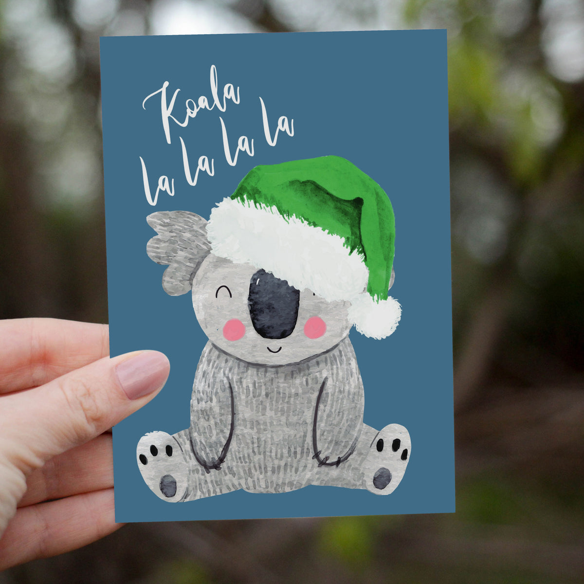Christmas card set with skeleton designs: one in a red pom-pom beanie over a red splash, one in a green Santa hat over a gree