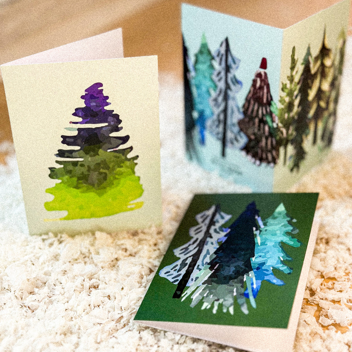 Watercolor-style abstract Christmas tree card set, 24 cards across 12 distinct color and design pairings.