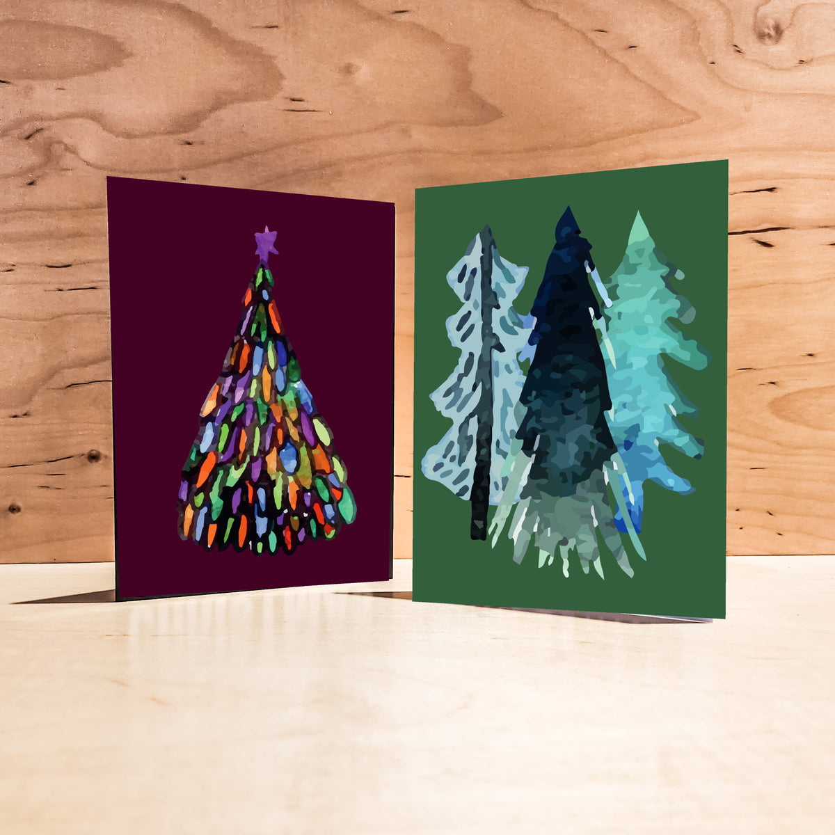 Assorted Christmas cards, 24 count, with abstract watercolor trees in varied palettes and background colors.