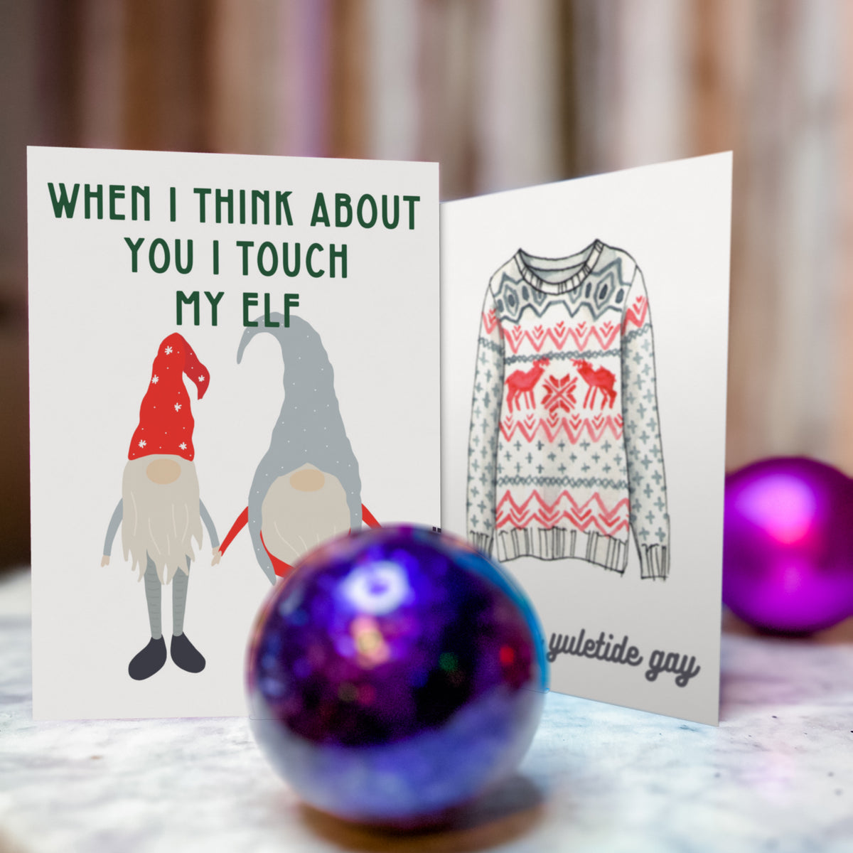 Bold red block text card reading "'TIS THE SEASON TO BE EVEN GAYER THAN USUAL" with gnome illustration.