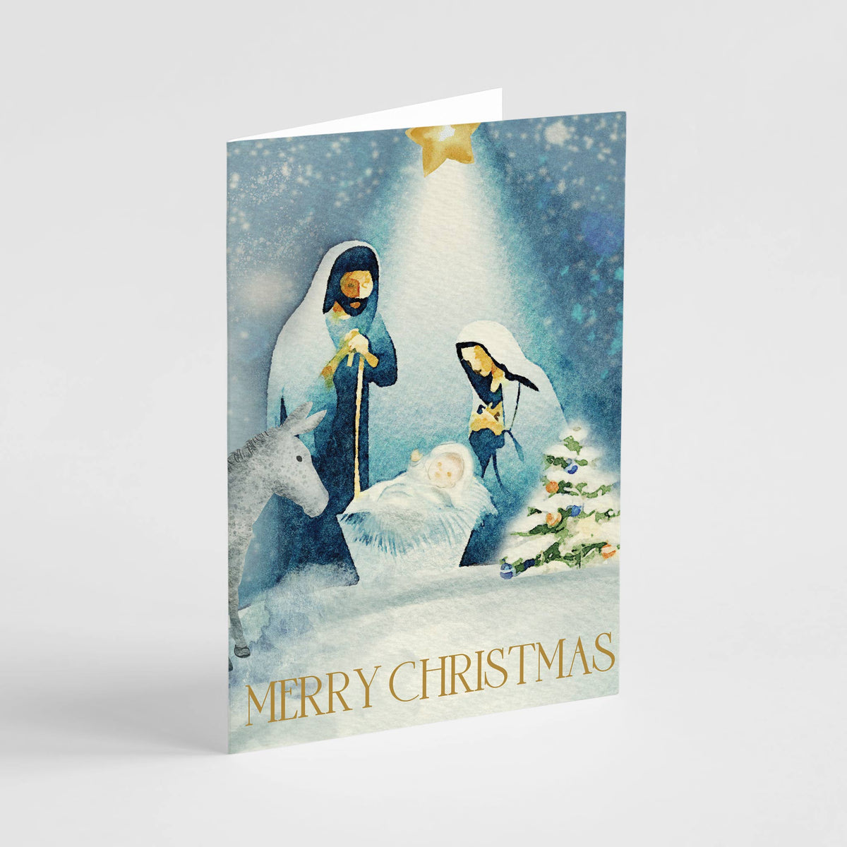 Nativity watercolor Christmas card with Mary, Joseph, baby Jesus, donkey, and gold star on deep blue background.