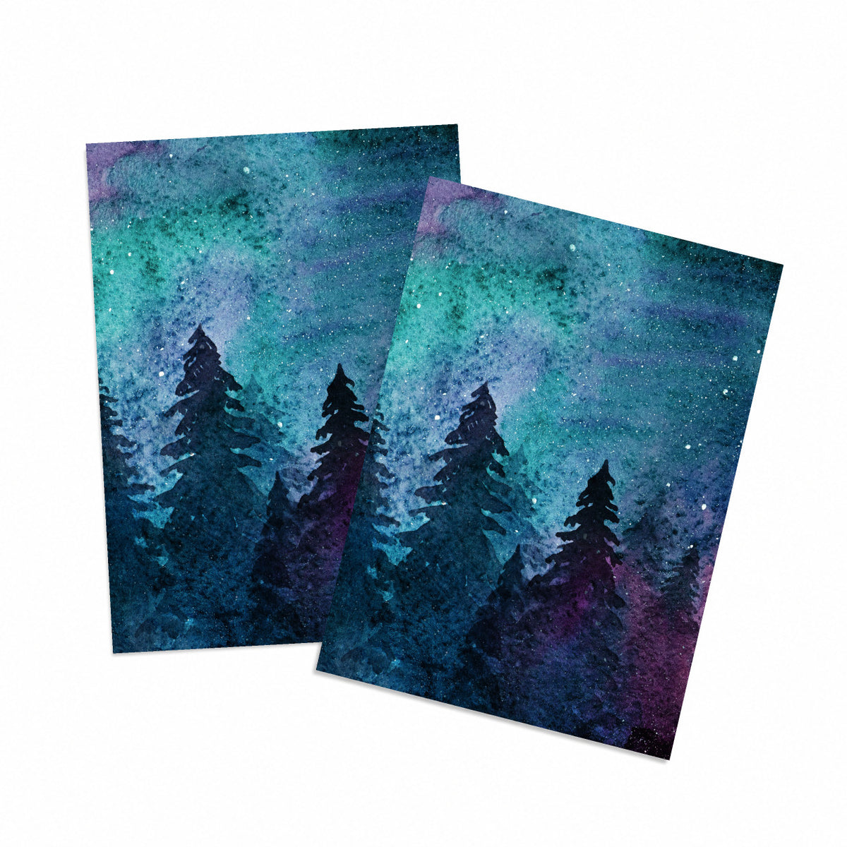 Folded holiday card with watercolor night sky over black silhouetted evergreen trees, teal, purple, and magenta tones.
