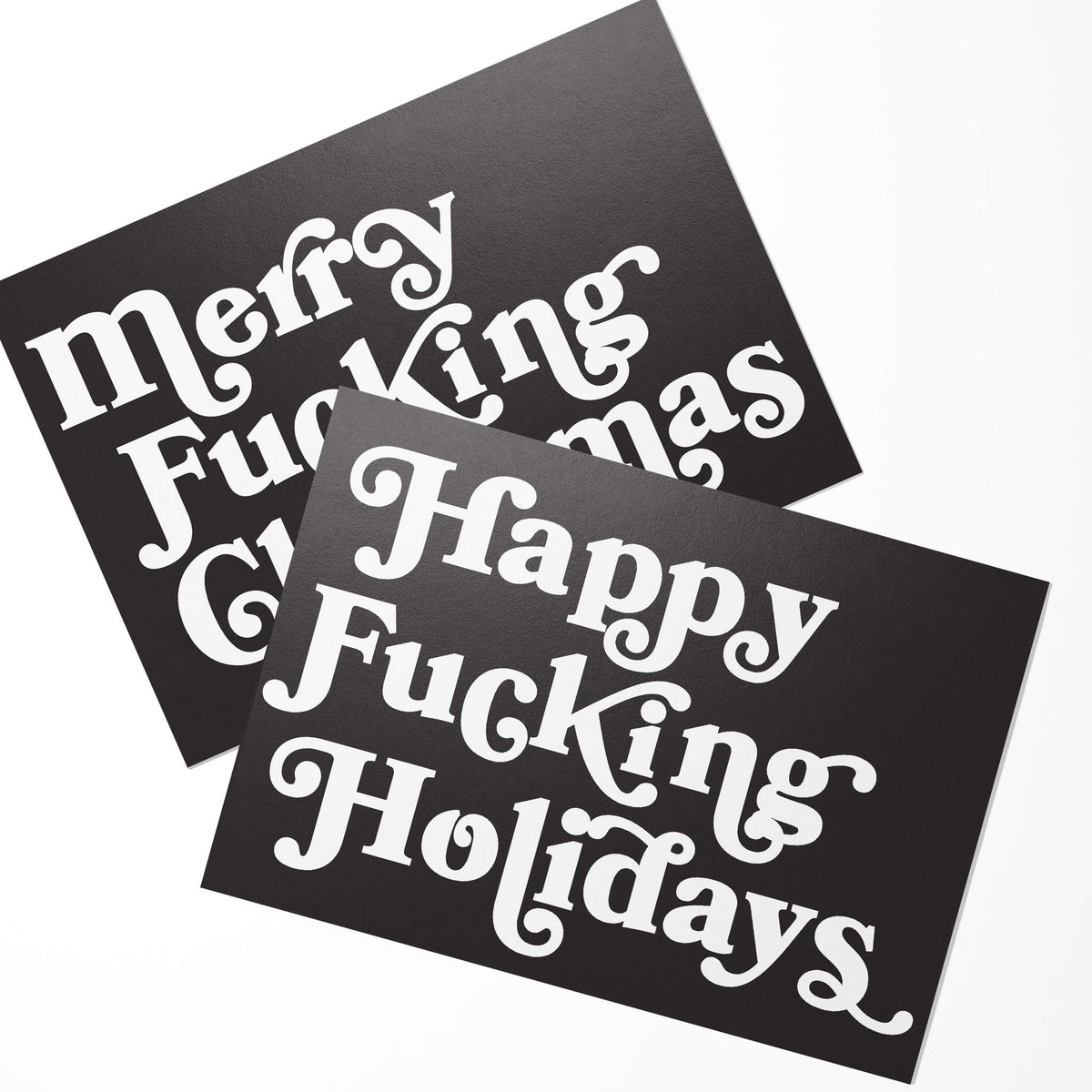 Merry Fucking Christmas and Happy Fucking Holidays cards, set of 24, two designs on near-black with white serif text.