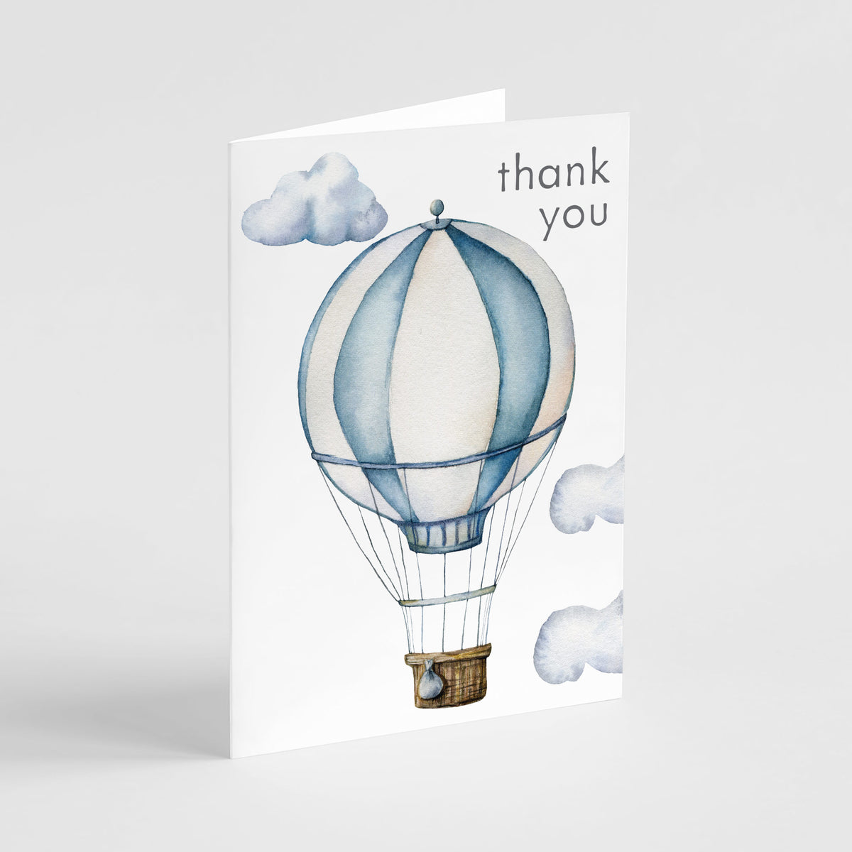 White thank you card with watercolor hot air balloon, dusty blue and cream panels, blue-gray clouds, charcoal lowercase text.