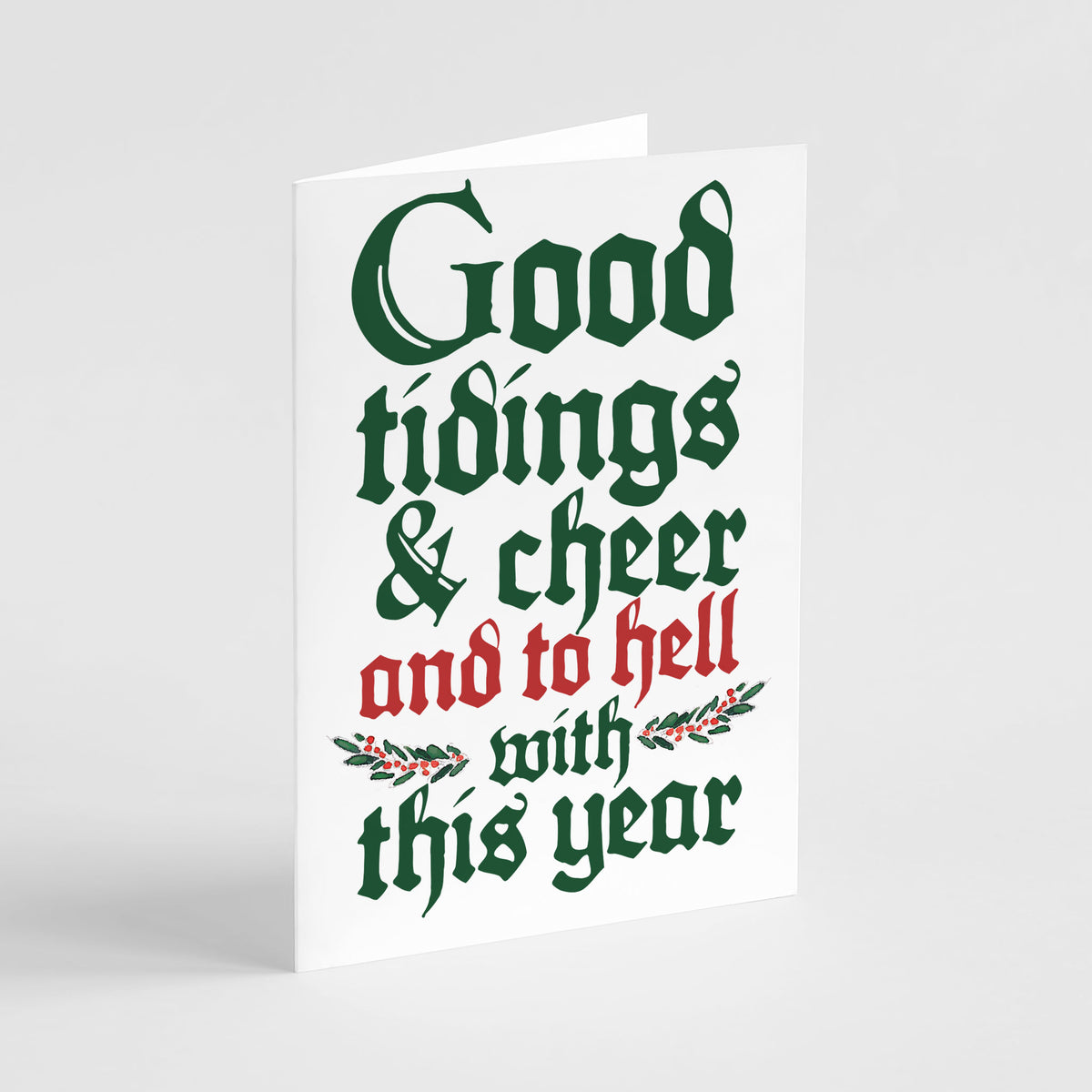 White card with stacked blackletter lettering in dark green and red, with a holly and berry sprig accent.