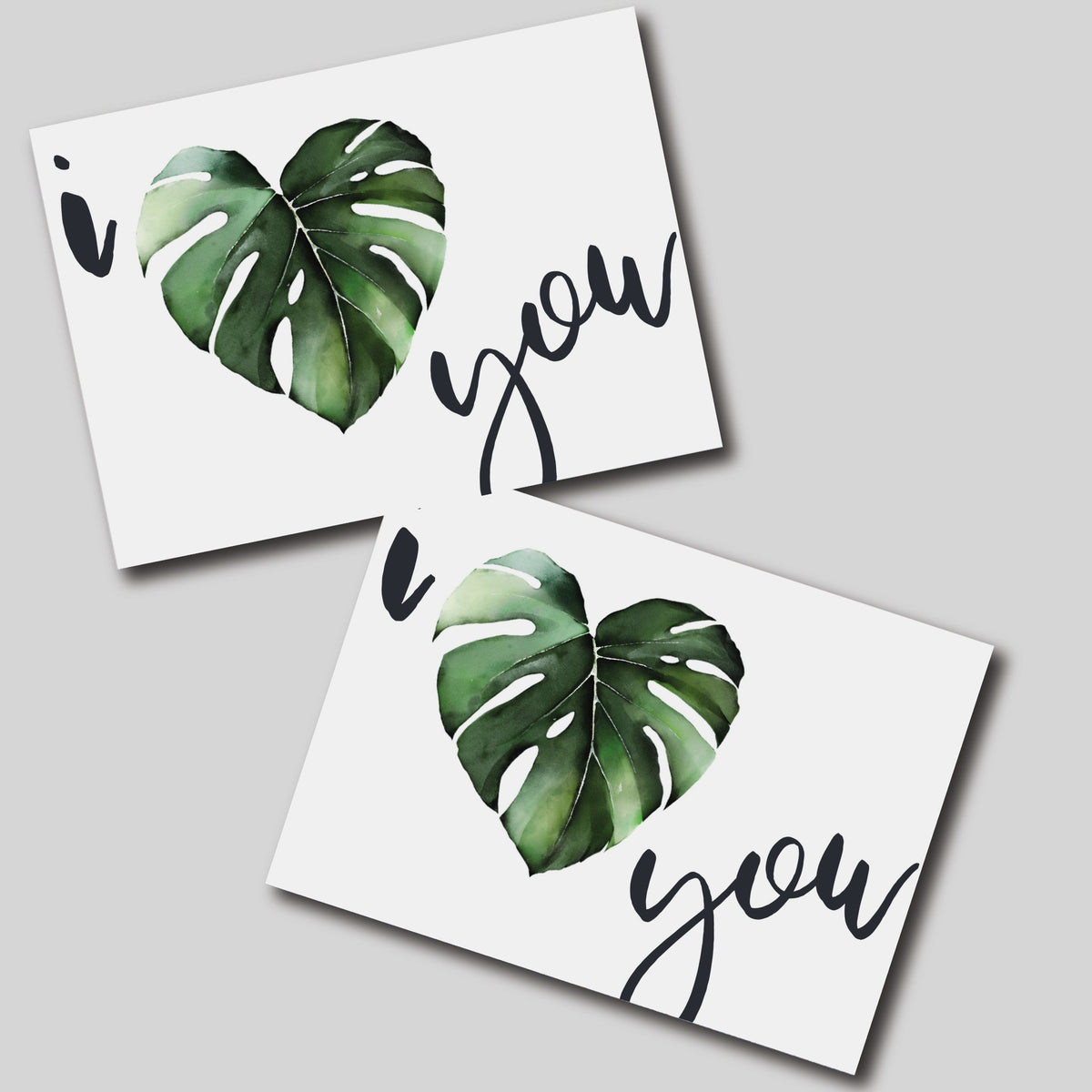 White notecard featuring a green heart-shaped monstera leaf centered between lowercase script "i" and "you."