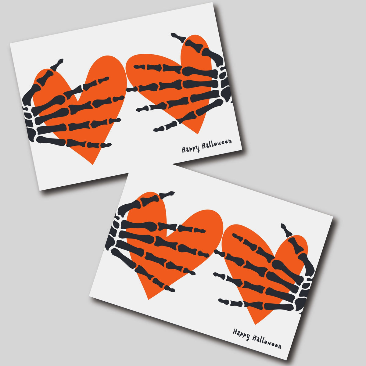 Card set featuring a flat black skeleton hand illustration on paired orange hearts, white card background.