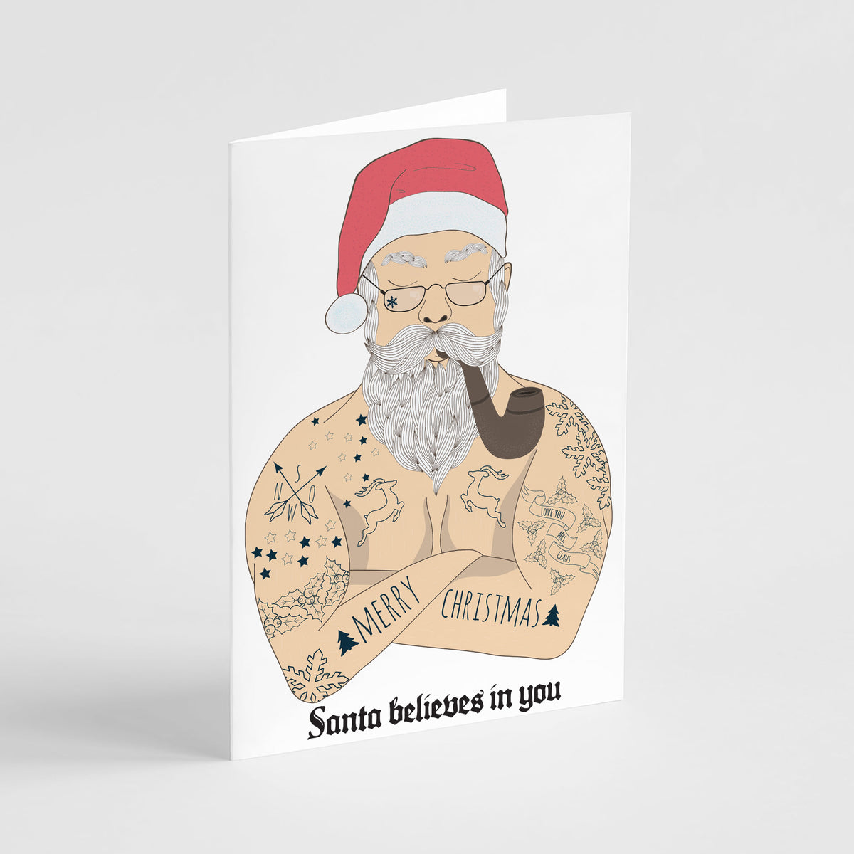 Christmas cards featuring a bare-chested illustrated Santa with full tattoos, white beard, red hat, and a smoking pipe.