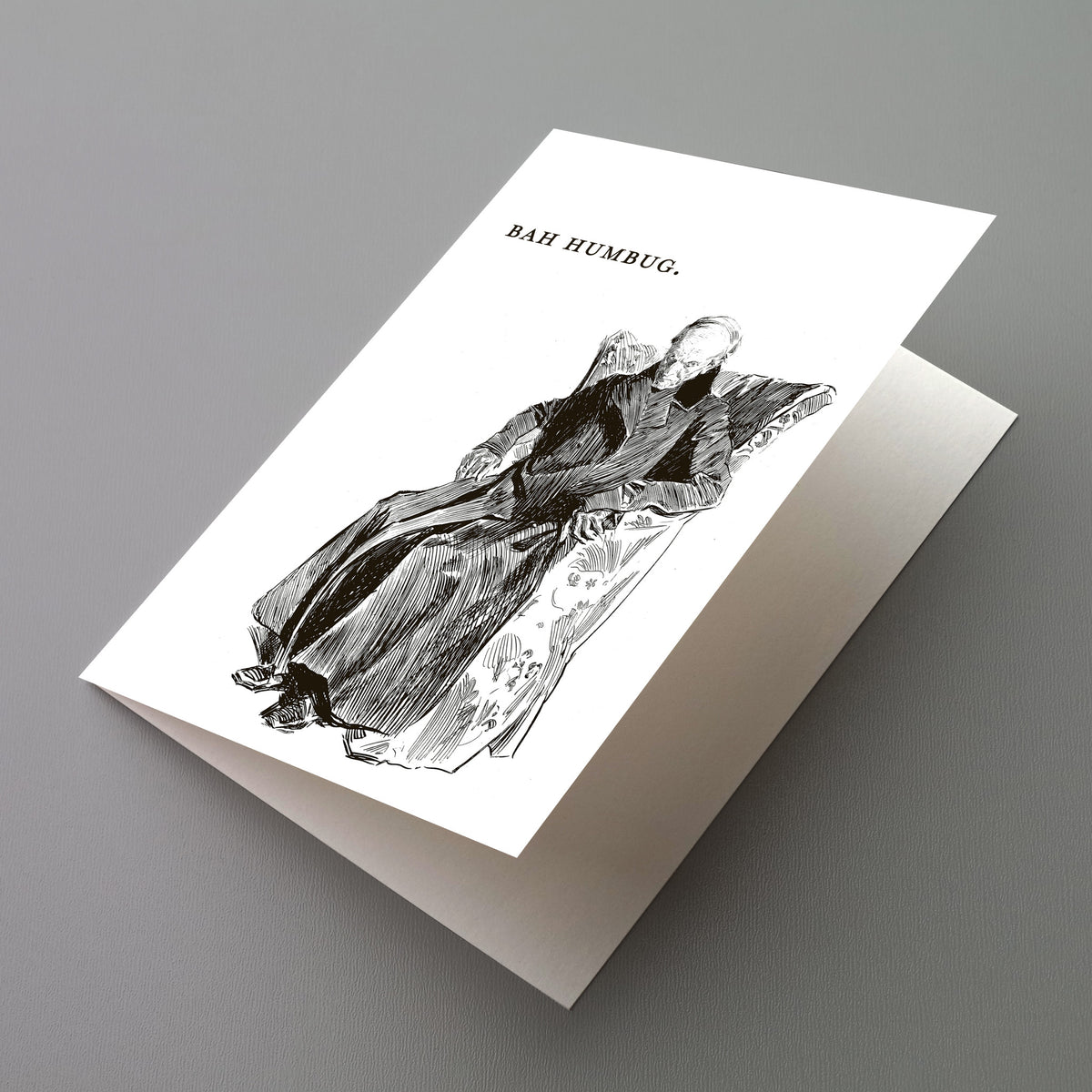 Christmas cards featuring a hatched line drawing of a hunched old man in a long coat seated in a floral wingback chair.