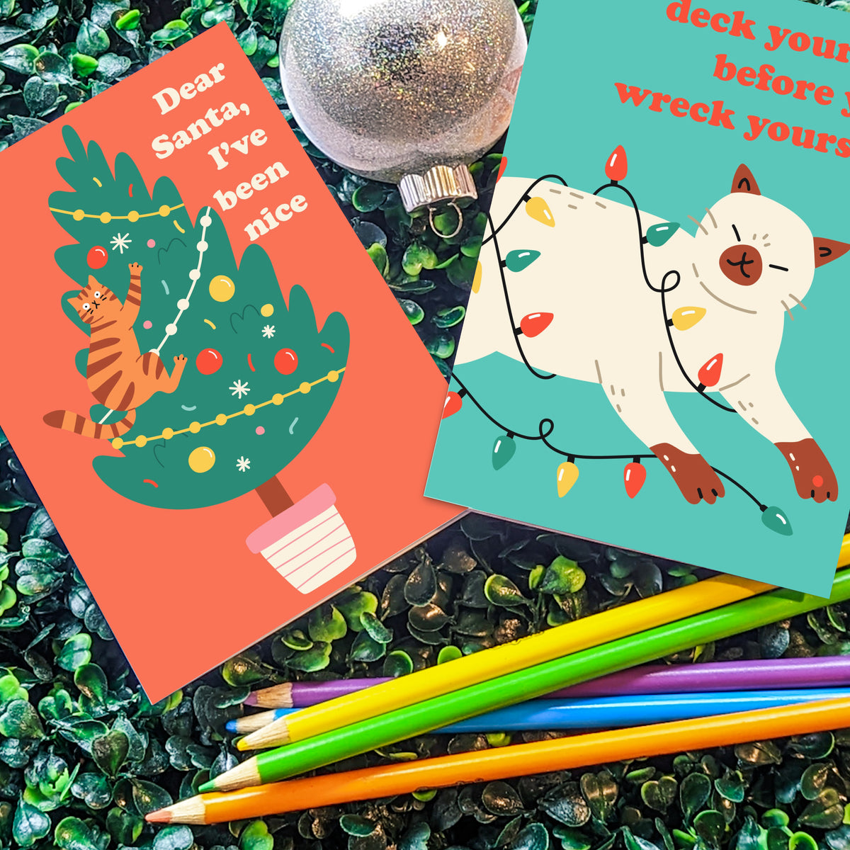 Christmas card set with 12 cat illustrations on teal, coral, mustard, and green backgrounds.