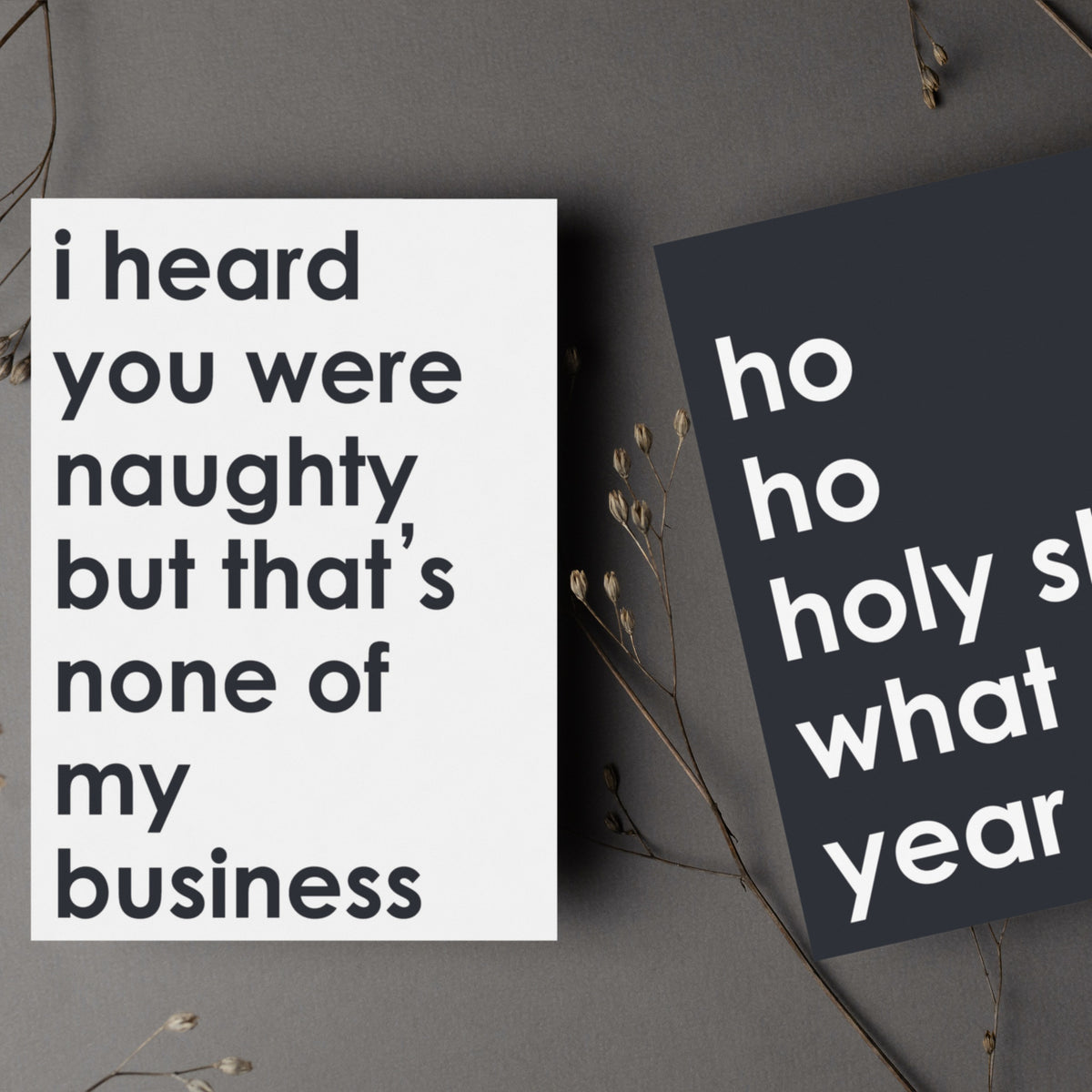 Holiday cards with humorous text printed in bold white lettering on black cardstock.