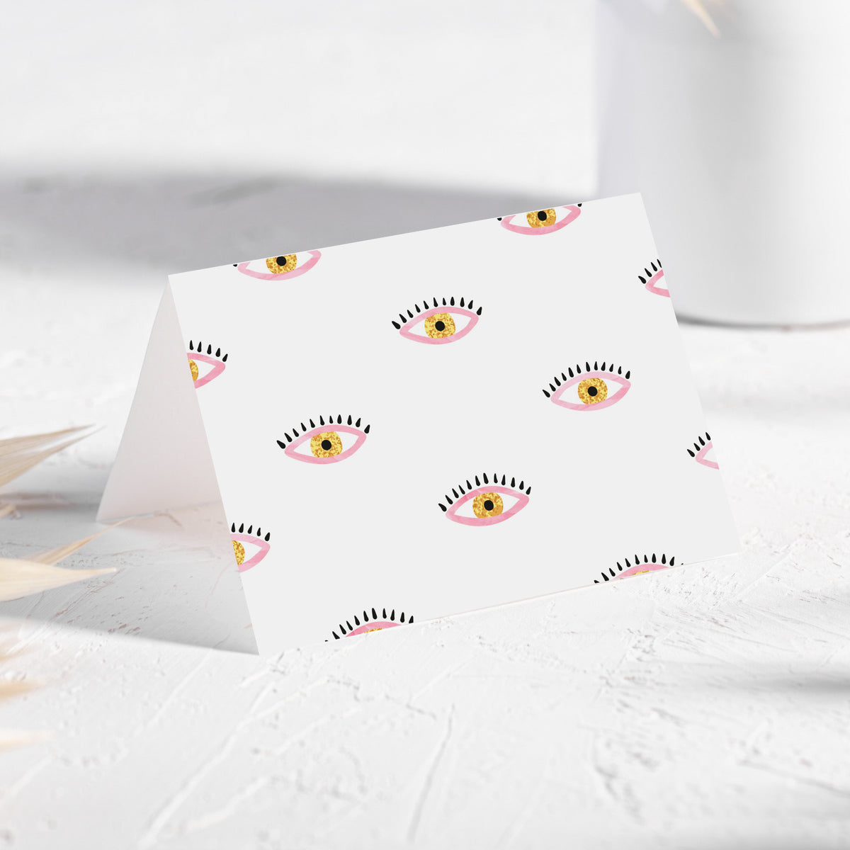 Illustrated notecard set with repeating eye motifs, black lashes, pink eyelids, and yellow irises.