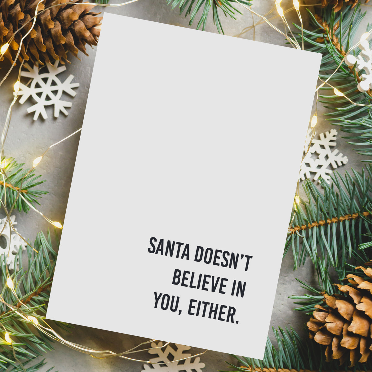 Folded white Christmas cards with bold condensed black capital letters, 12 designs, 2 of each.