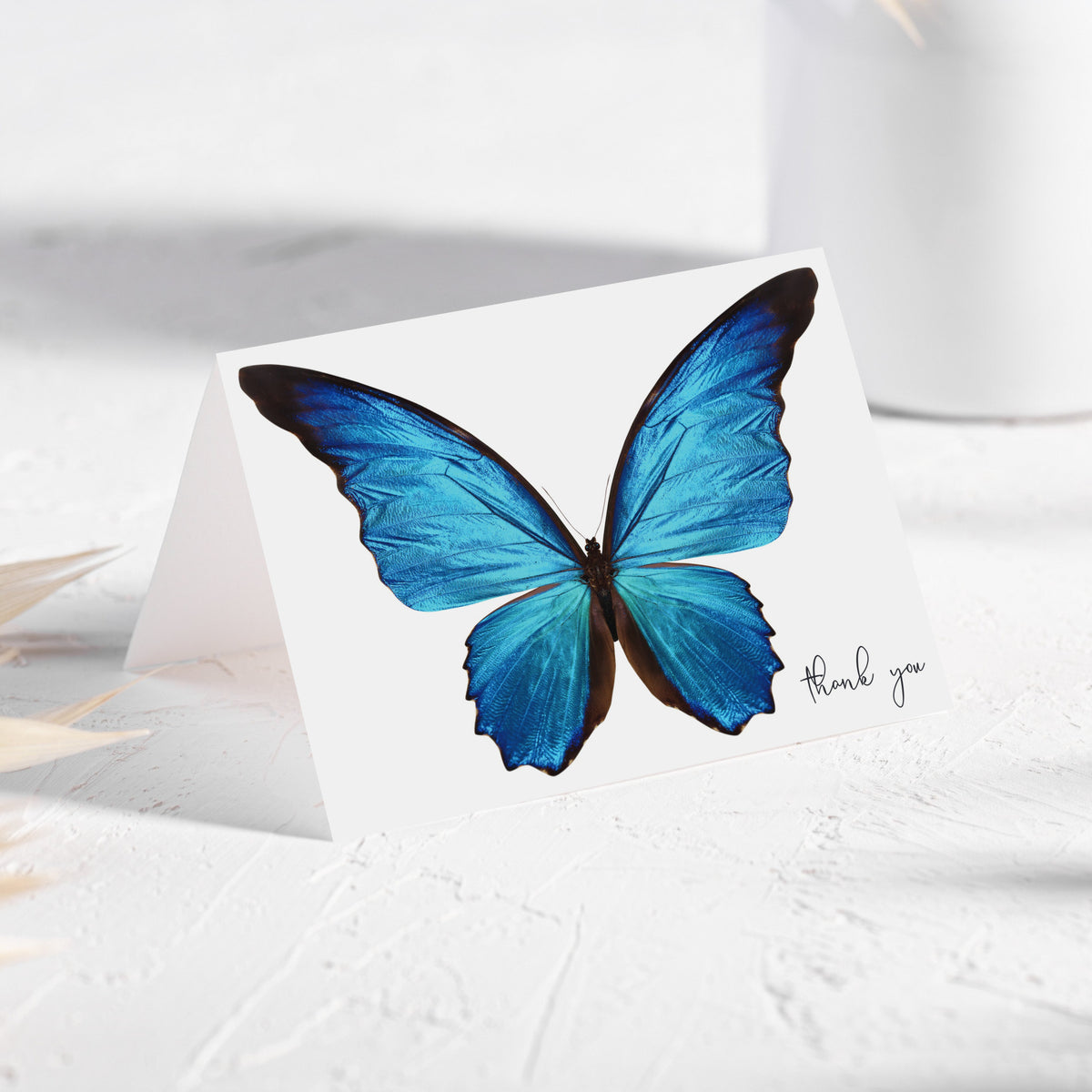 Thank you cards with a detailed butterfly illustration, cyan and cobalt blue wings, dark brown borders, white background.