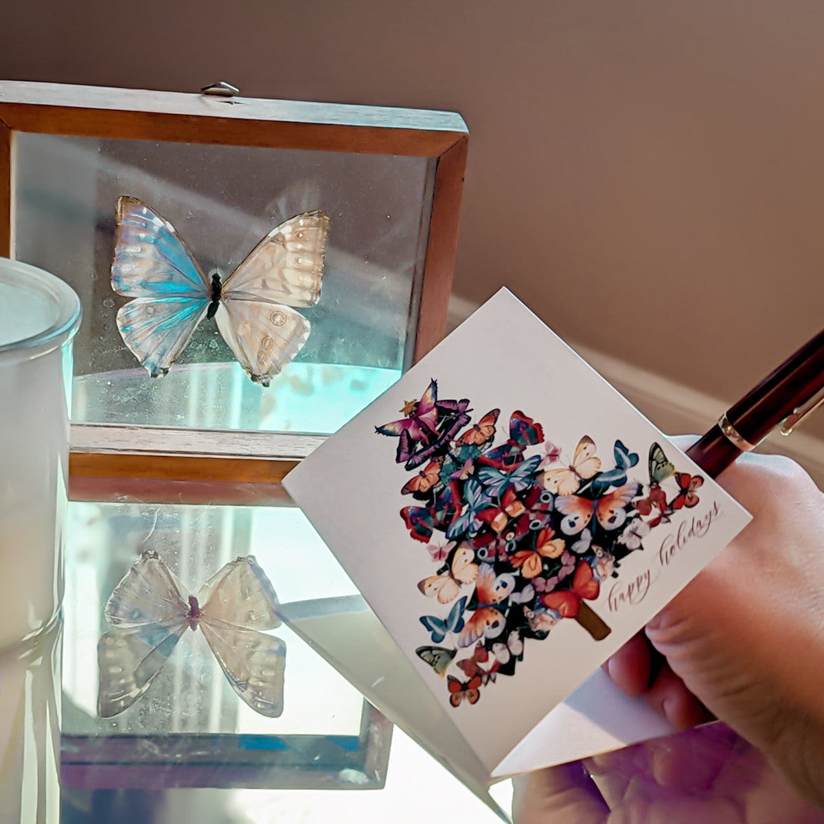 Holiday card featuring a butterfly-and-moth Christmas tree with a winged fairy topper holding a gold star.