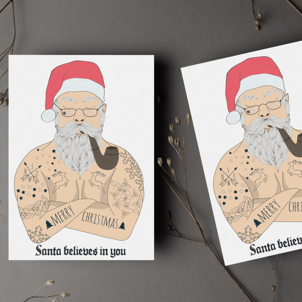 Set of 24 identical Christmas cards showing a heavily tattooed shirtless Santa figure holding a pipe.