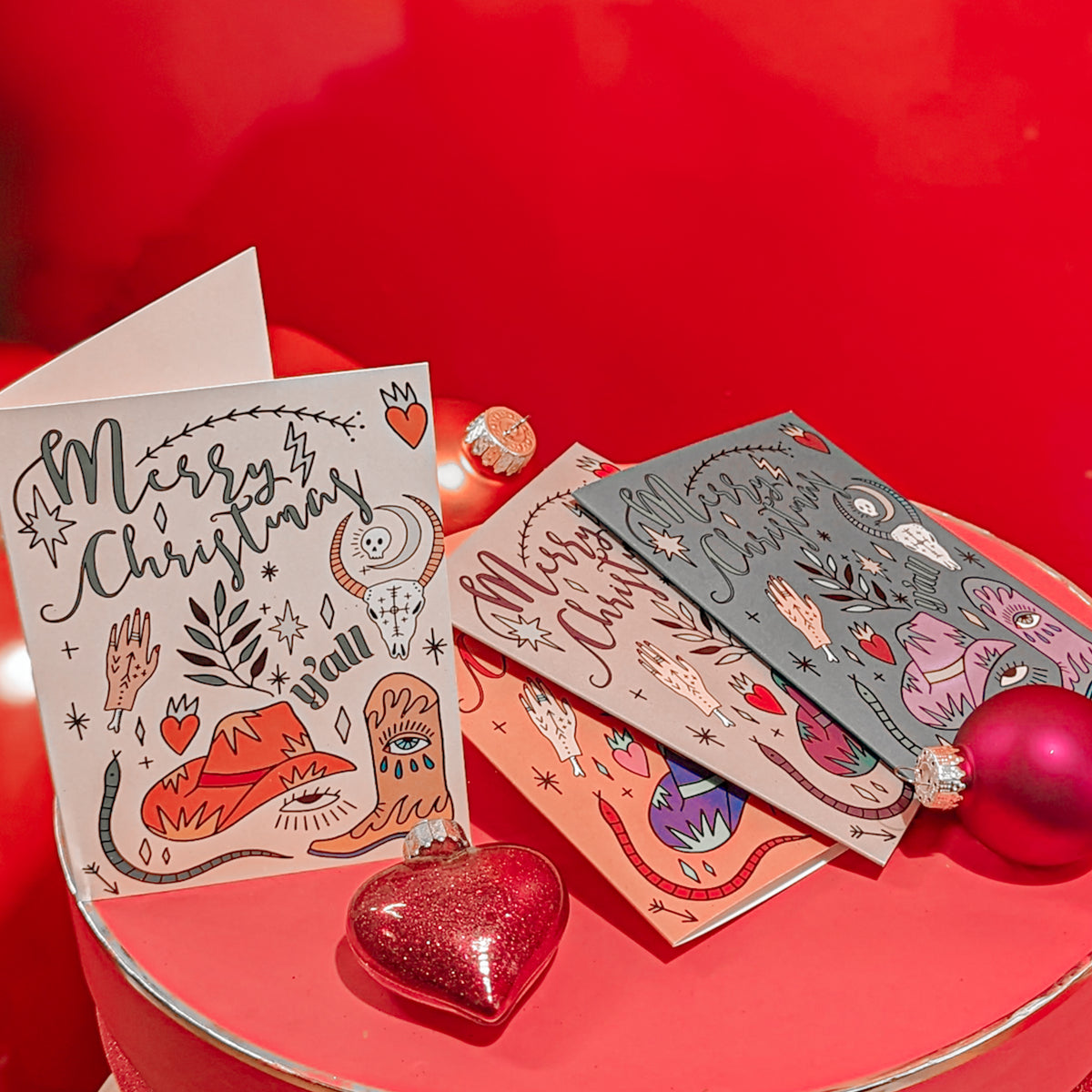Set of 24 holiday cards in four colorways, six of each design, portrait orientation, full-bleed background color.