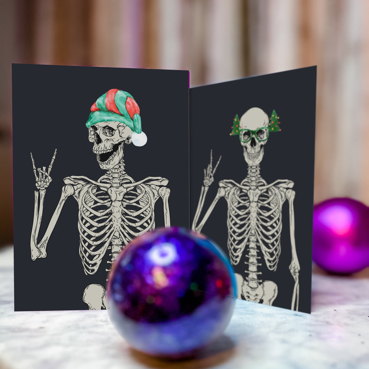 Christmas cards showing a detailed skeleton illustration in a red Santa hat on a solid black card front.