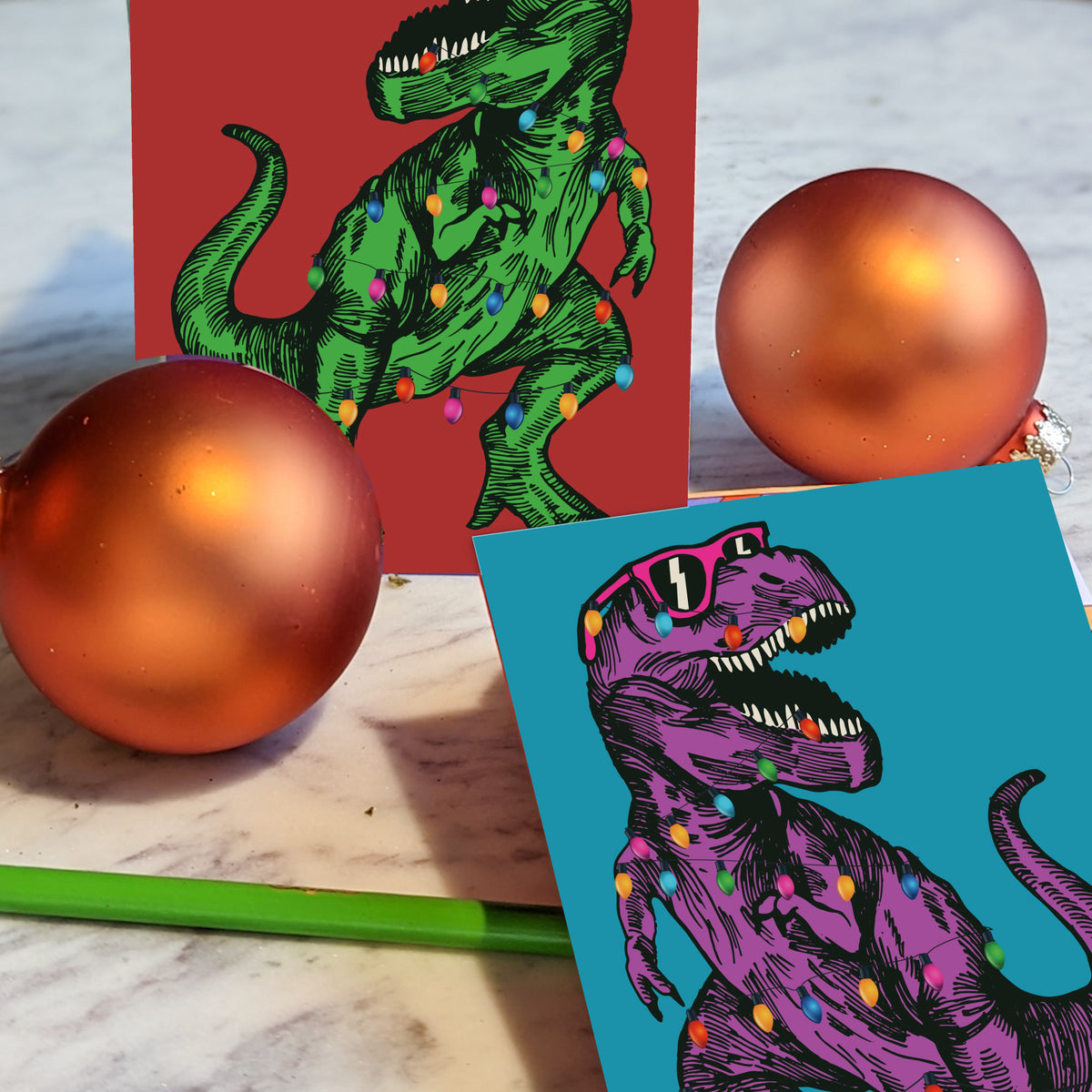 Christmas card set with an engraving-style Tyrannosaurus rex tangled in C9 bulb lights, 12 cards per design.