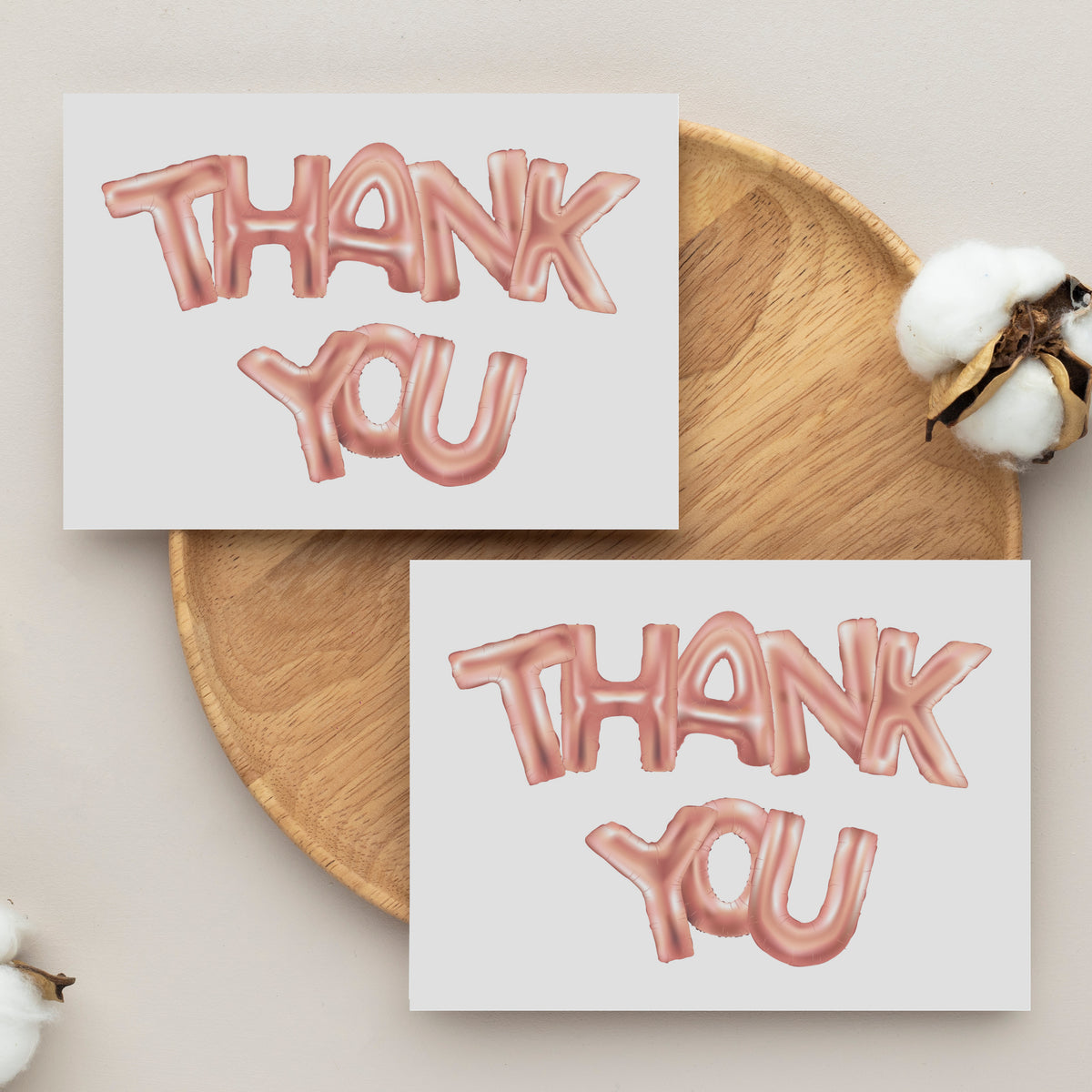 Set of 24 thank you note cards with centered metallic pink balloon-style typography on white.