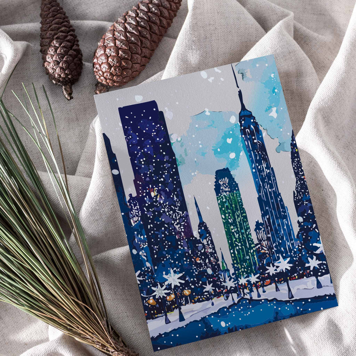Pack of 24 cards with navy, teal, and aqua watercolor illustrations of New York City winter scenes.
