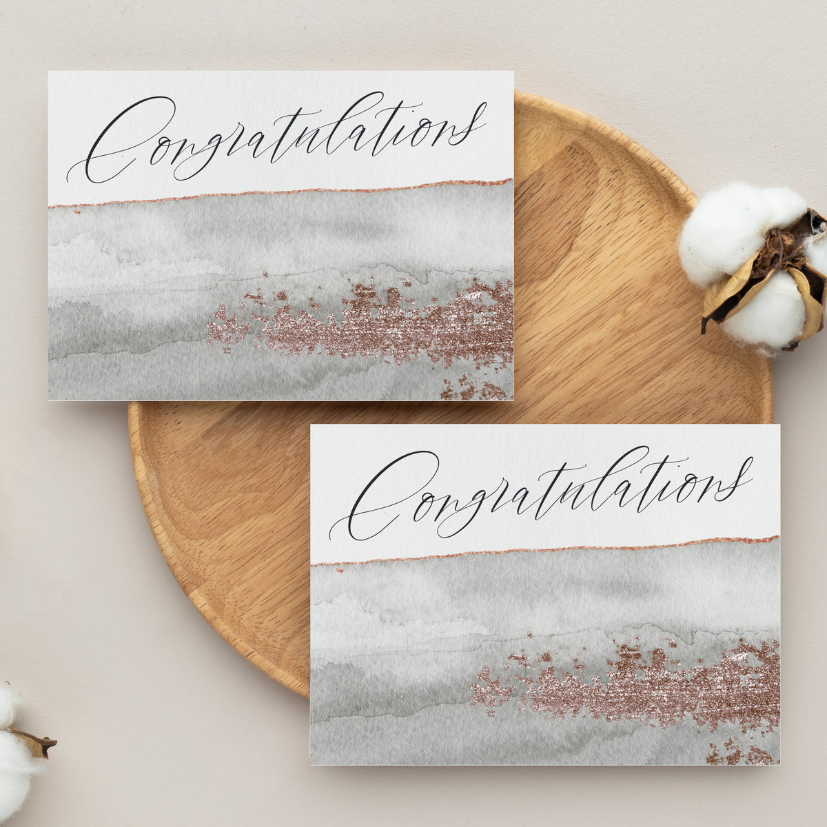 Congratulations card with script typography and a watercolor-style graphic band in neutral gray, white, and rose gold hues.