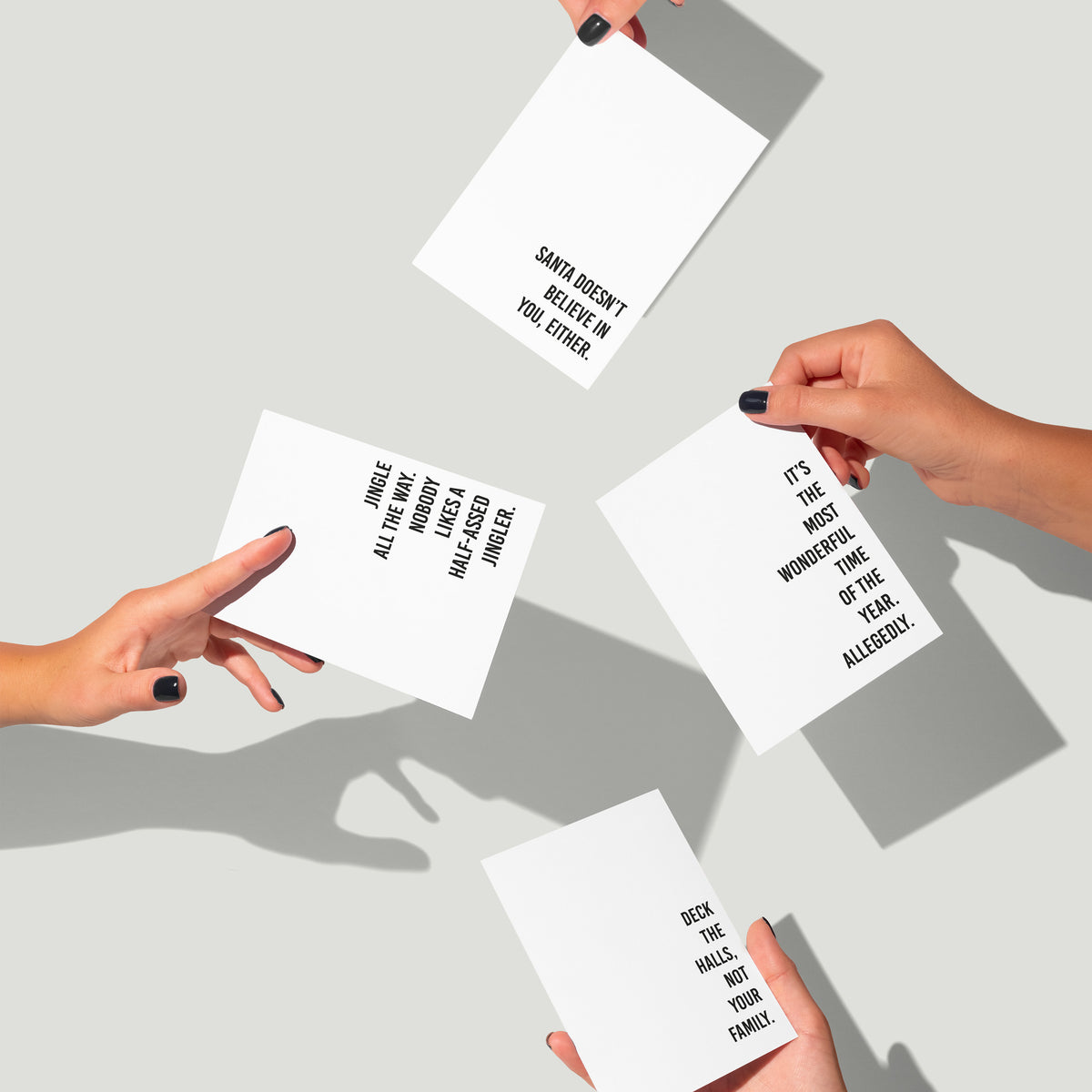 Christmas card set, each card printed with a single sarcastic phrase in all-caps black text.