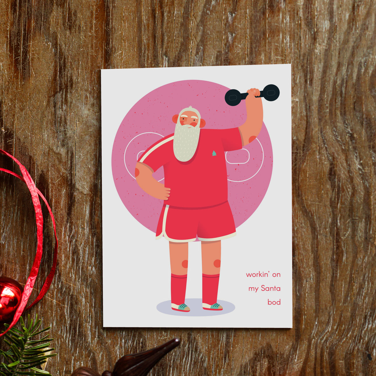 Boxed Christmas card set, 24 cards across four designs showing Santa doing dumbbell, core, jump rope, and balance exercises.