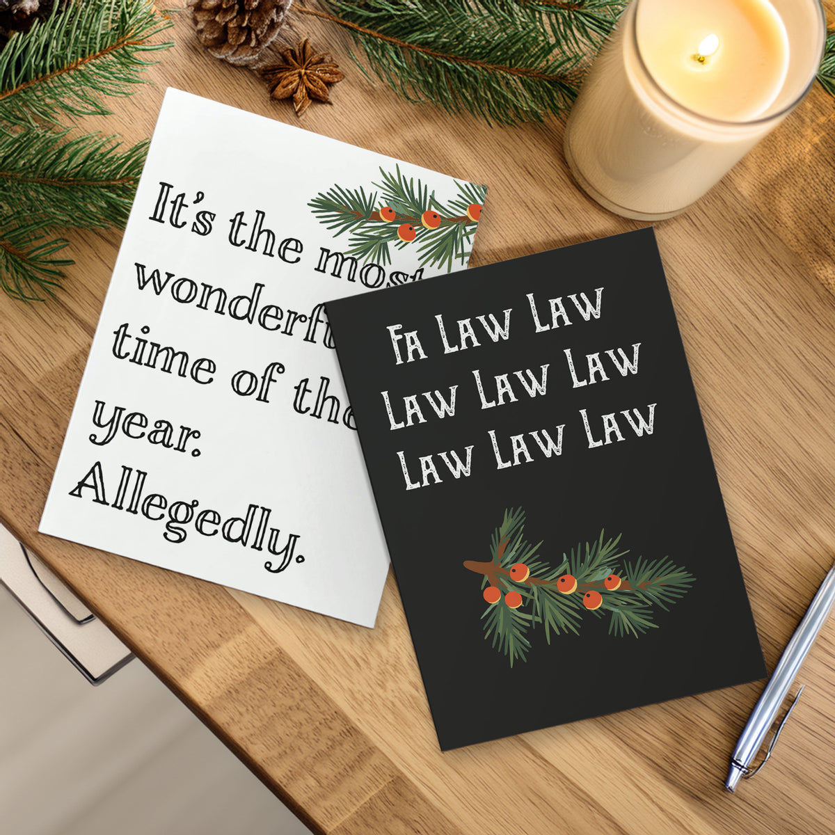 Christmas cards with slab-serif text and pine branch accents; one black background design, one off-white background design.