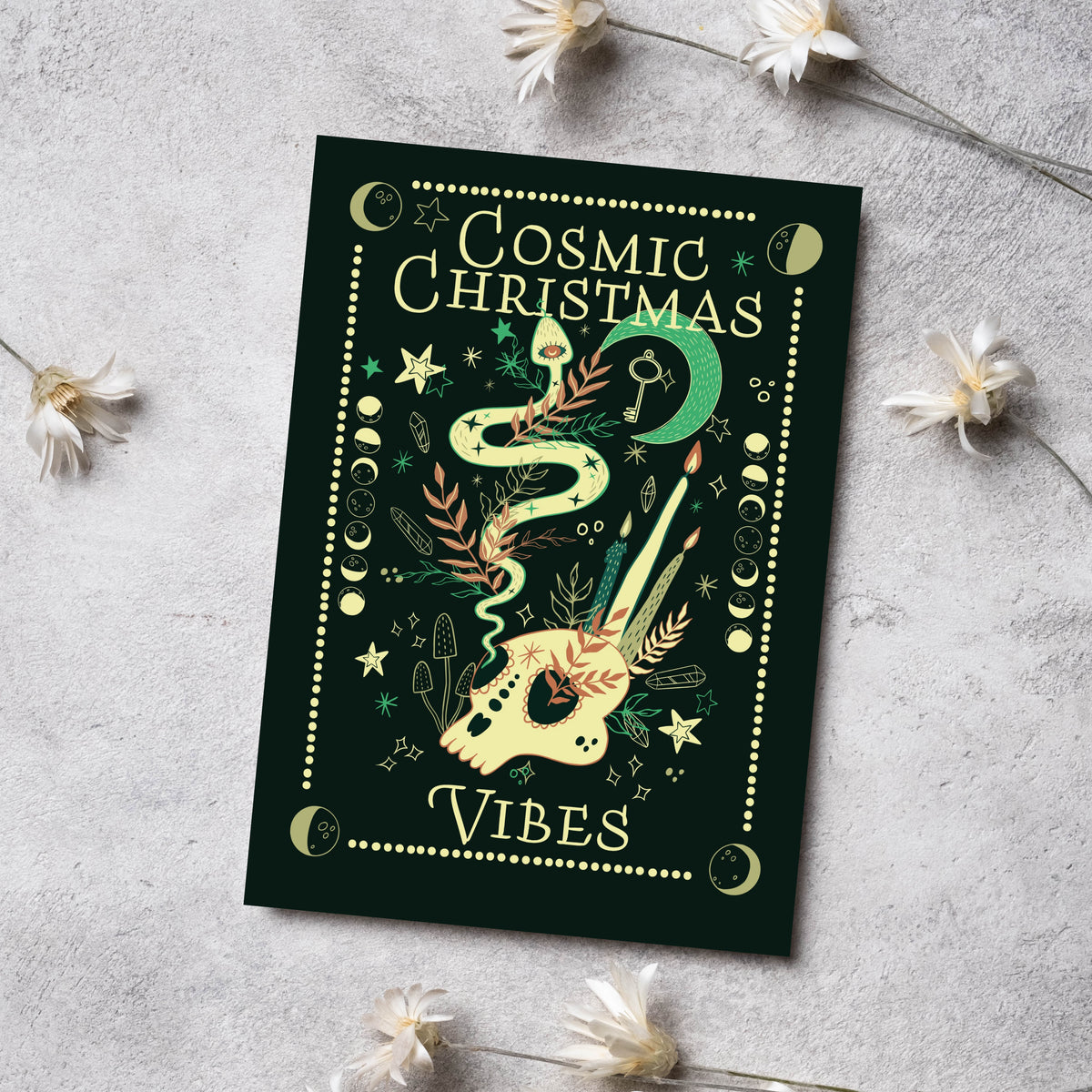 Dark green holiday cards with cream skulls, snakes, hourglasses, and palm eye symbols in a witchy illustrated style.