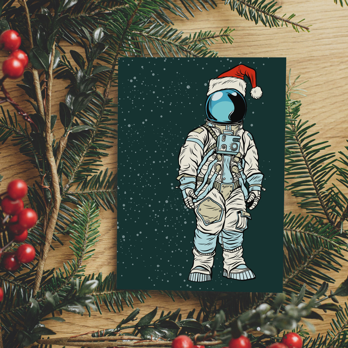 Pack of holiday cards with illustrated astronaut in white space suit and red Santa hat, teal background.