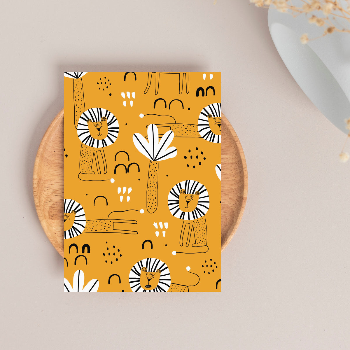 Greeting card set with black-outlined lions, circular striped manes, and white palm frond motifs on mustard yellow.