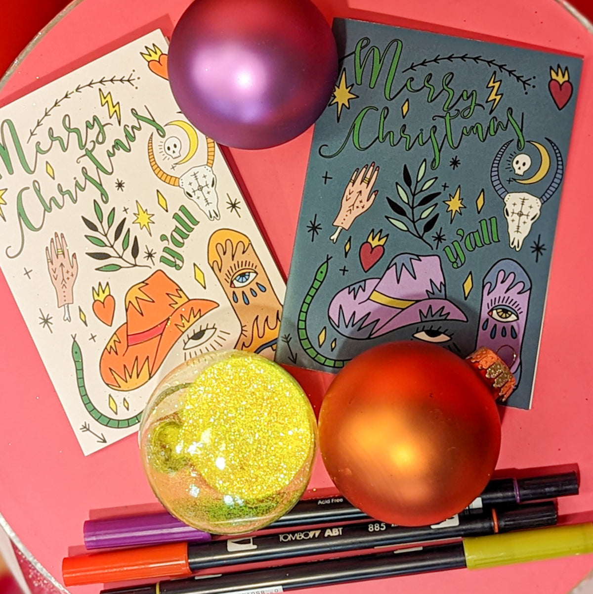 Four Christmas card designs sharing illustrated Western motifs including a longhorn skull, coiled snake, and sacred heart.
