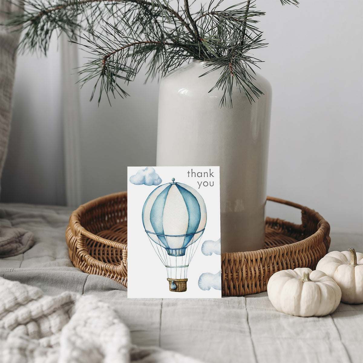 Watercolor hot air balloon card with alternating dusty blue and off-white vertical panels, tan basket, and muted cloud accent