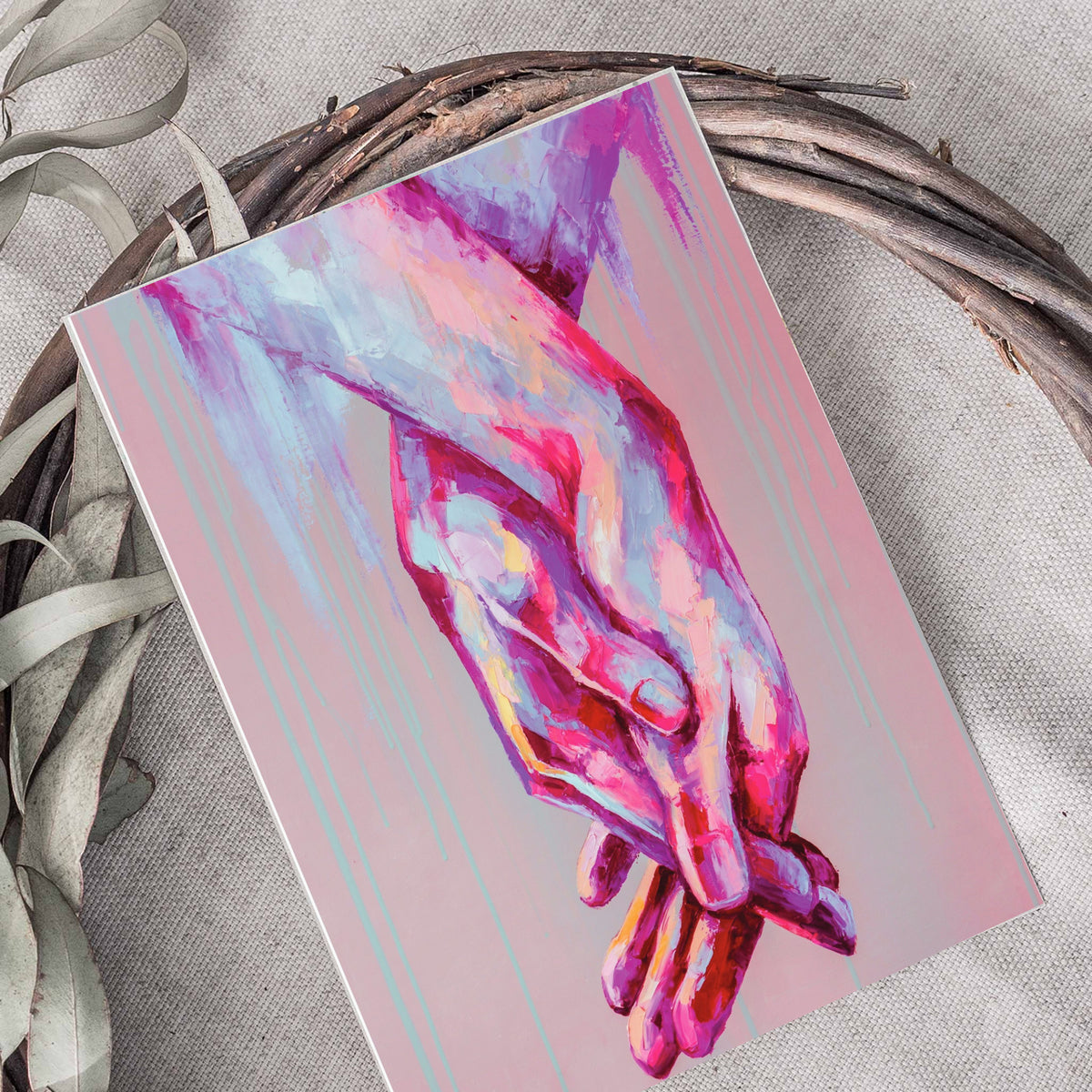 Cards depicting two hands reaching downward with fingers interlaced, painted in thick brushstroke marks on a mauve background