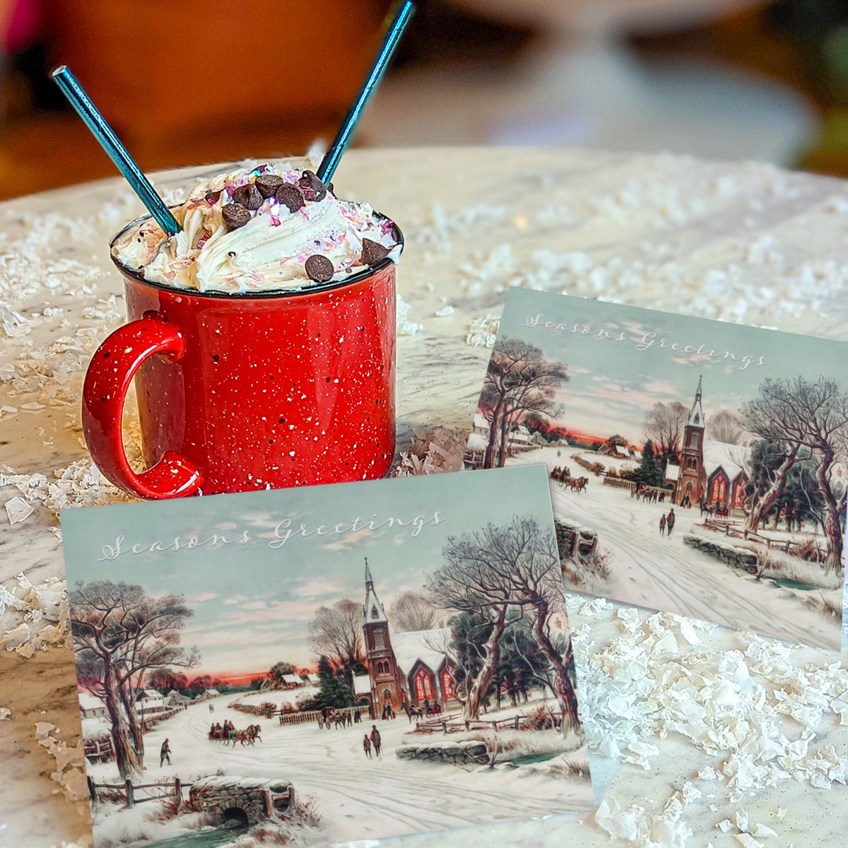 Winter village Christmas cards with a horse-drawn sleigh, evergreens, and white cursive "Season's Greetings" text overlay.