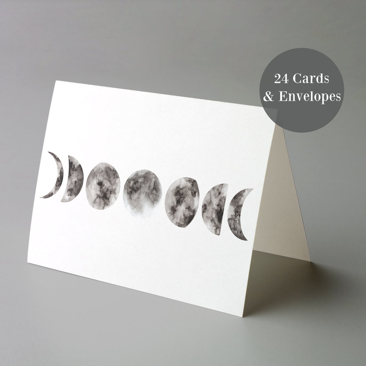 Pack of 24 minimalist notecards with a single monochrome lunar illustration on each card front.