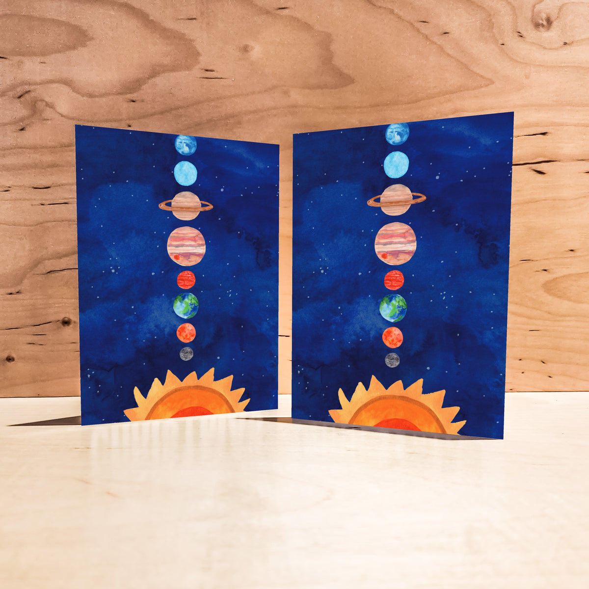Notecards depicting the Sun and eight planets in order on a deep navy watercolor background with scattered white stars.
