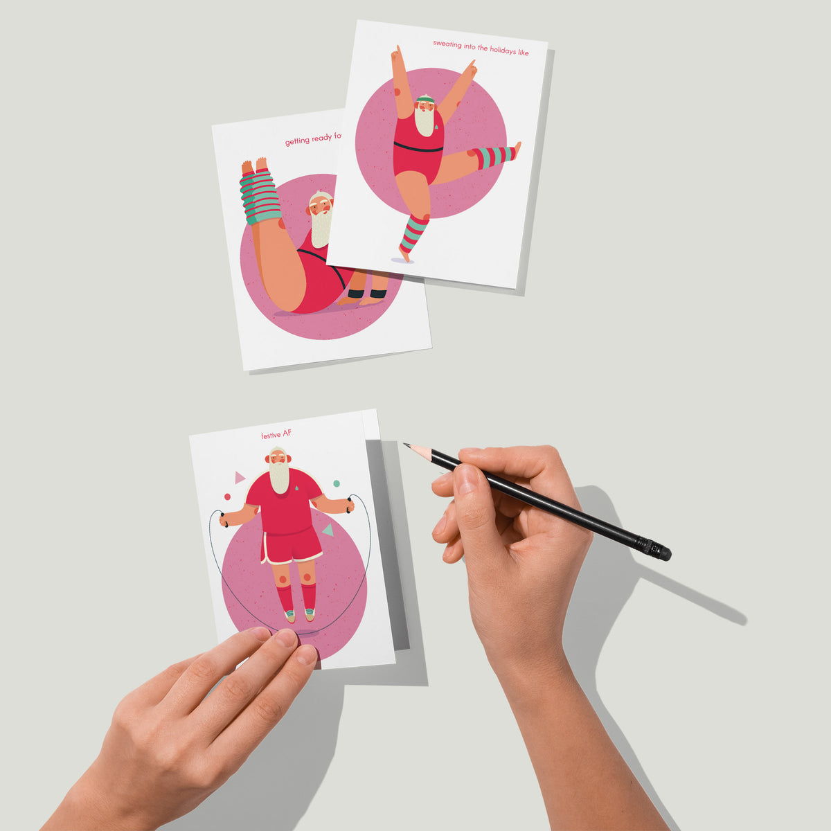 Four-design holiday card set, 6 cards per design, Santa in red athletic wear on a speckled pink circle.