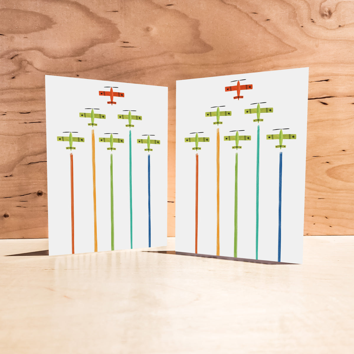 Set of 24 matching cards showing stylized propeller planes flying in formation with descending color smoke trails.