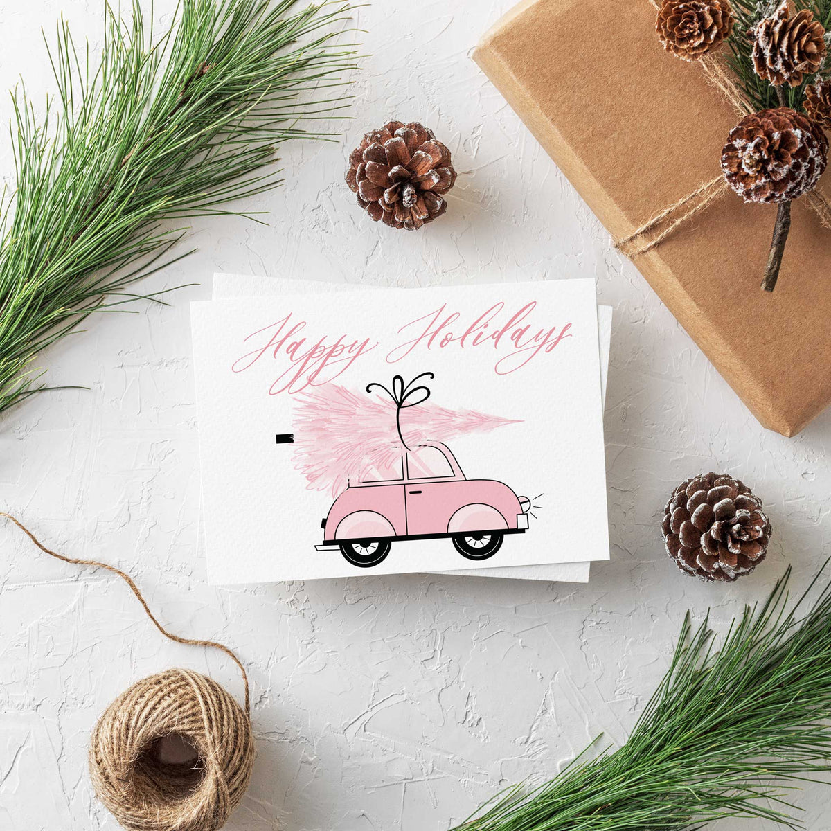 Assorted holiday cards, 24 total, eight designs mixing pink brushstroke illustration and connected script lettering.