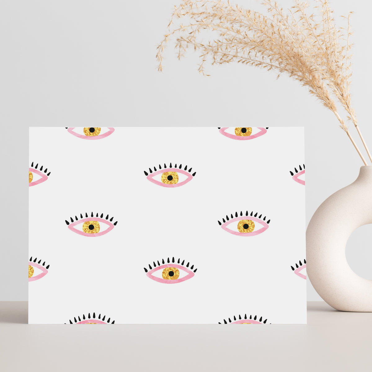 Notecard set with graphic eye illustrations on a white background and a pink background with black dash marks.