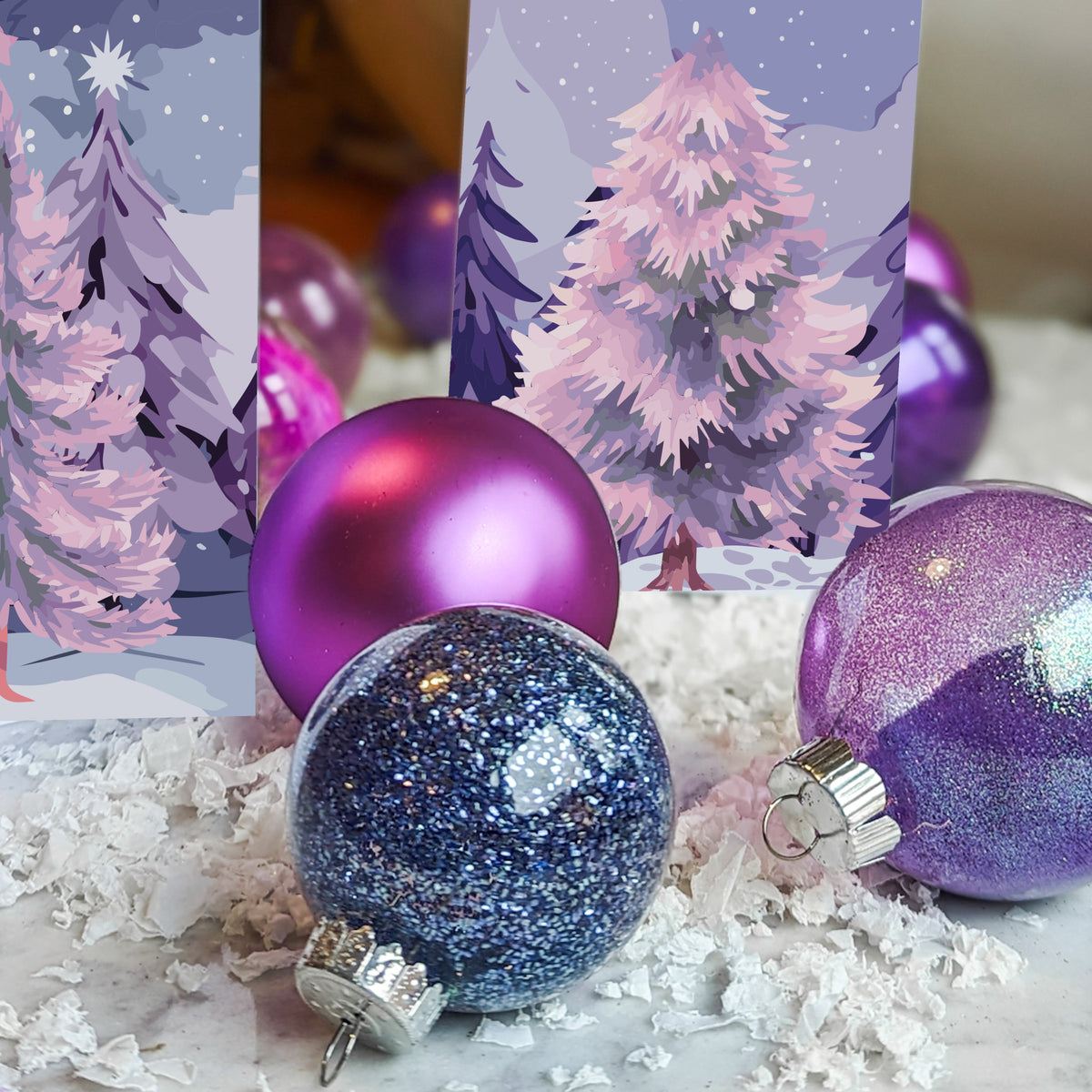 Holiday card set showing layered brushstroke-style illustrations of winter trees in lavender and pink.