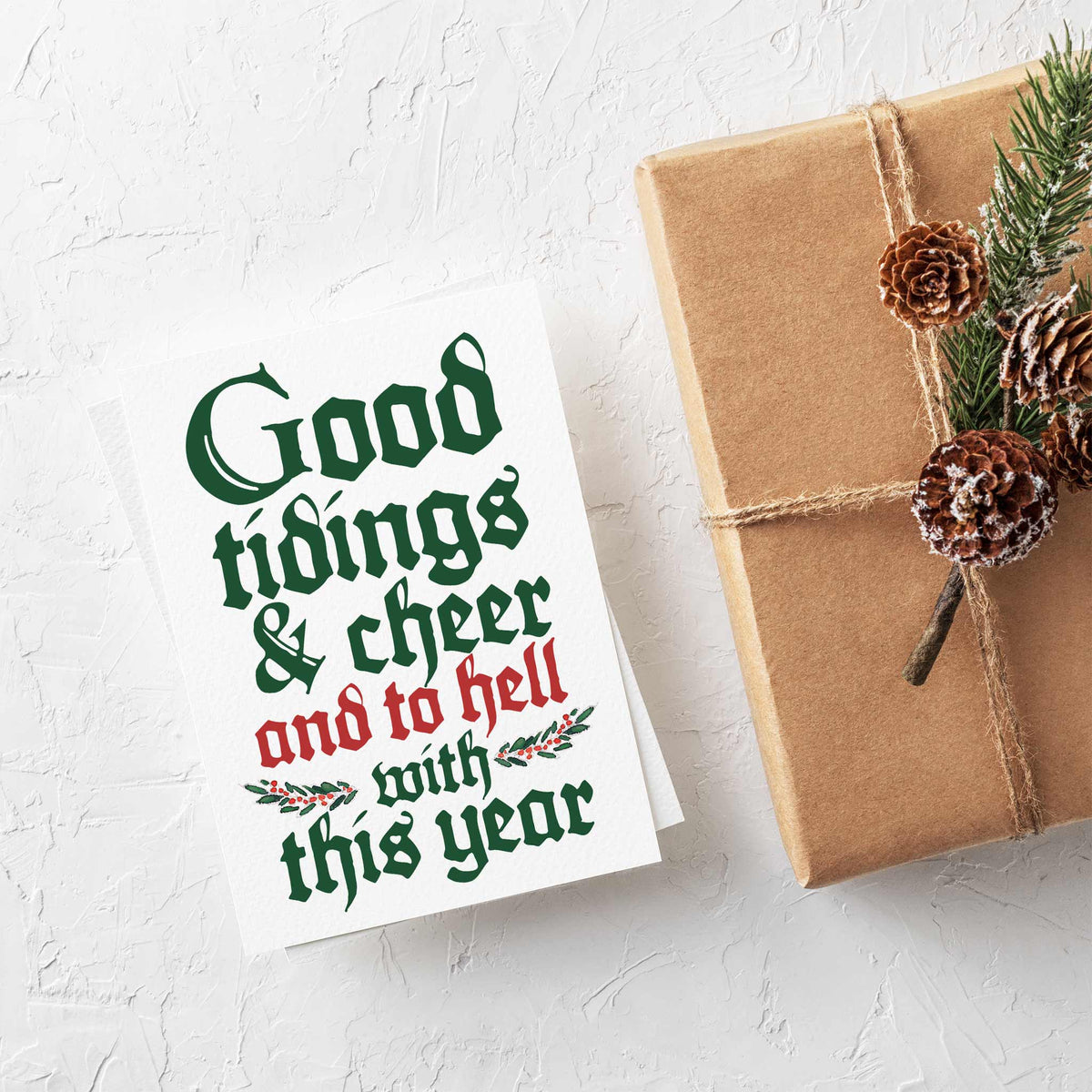 Holiday card printed with four lines of blackletter text, alternating dark green and red, holly sprig between lines.