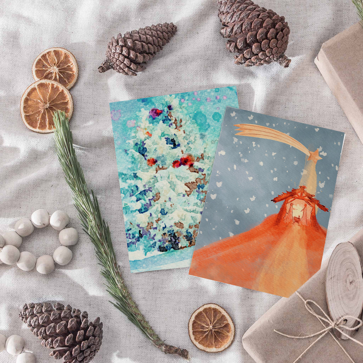 Card boxed set with blue, teal, purple, and gold watercolor nativity illustrations.